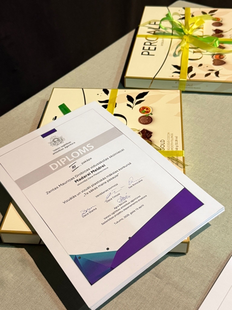 uz galda diploms un divas konfekšu kastes