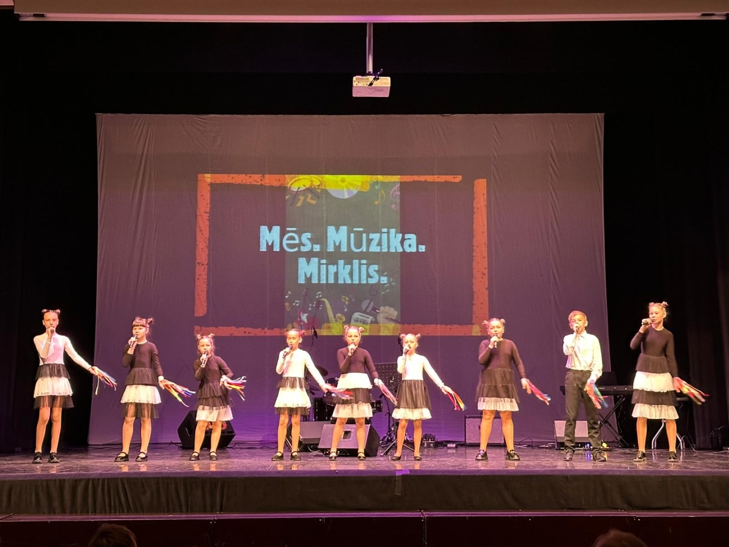 uzstājas bērnu ansamblis melnbaltos tērpos